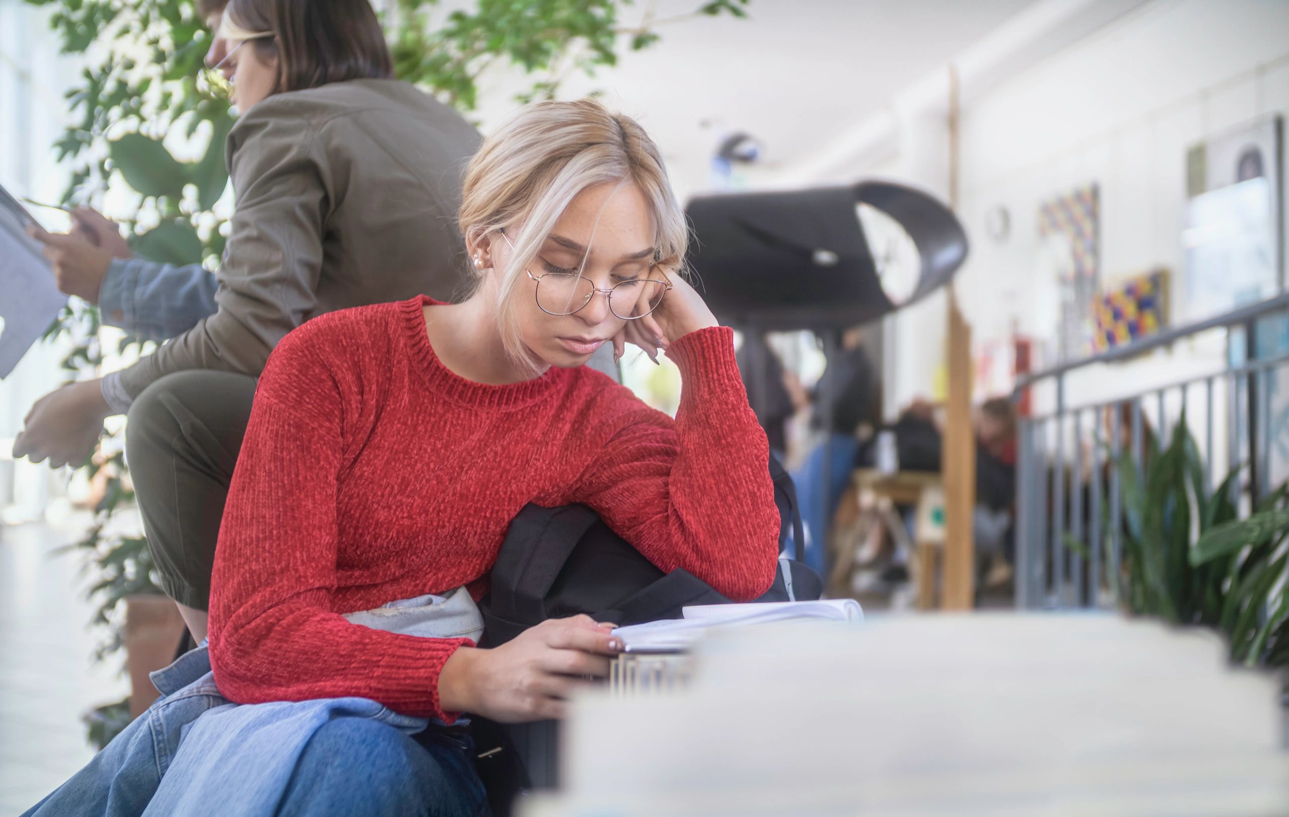 High school student reading in a school hallway