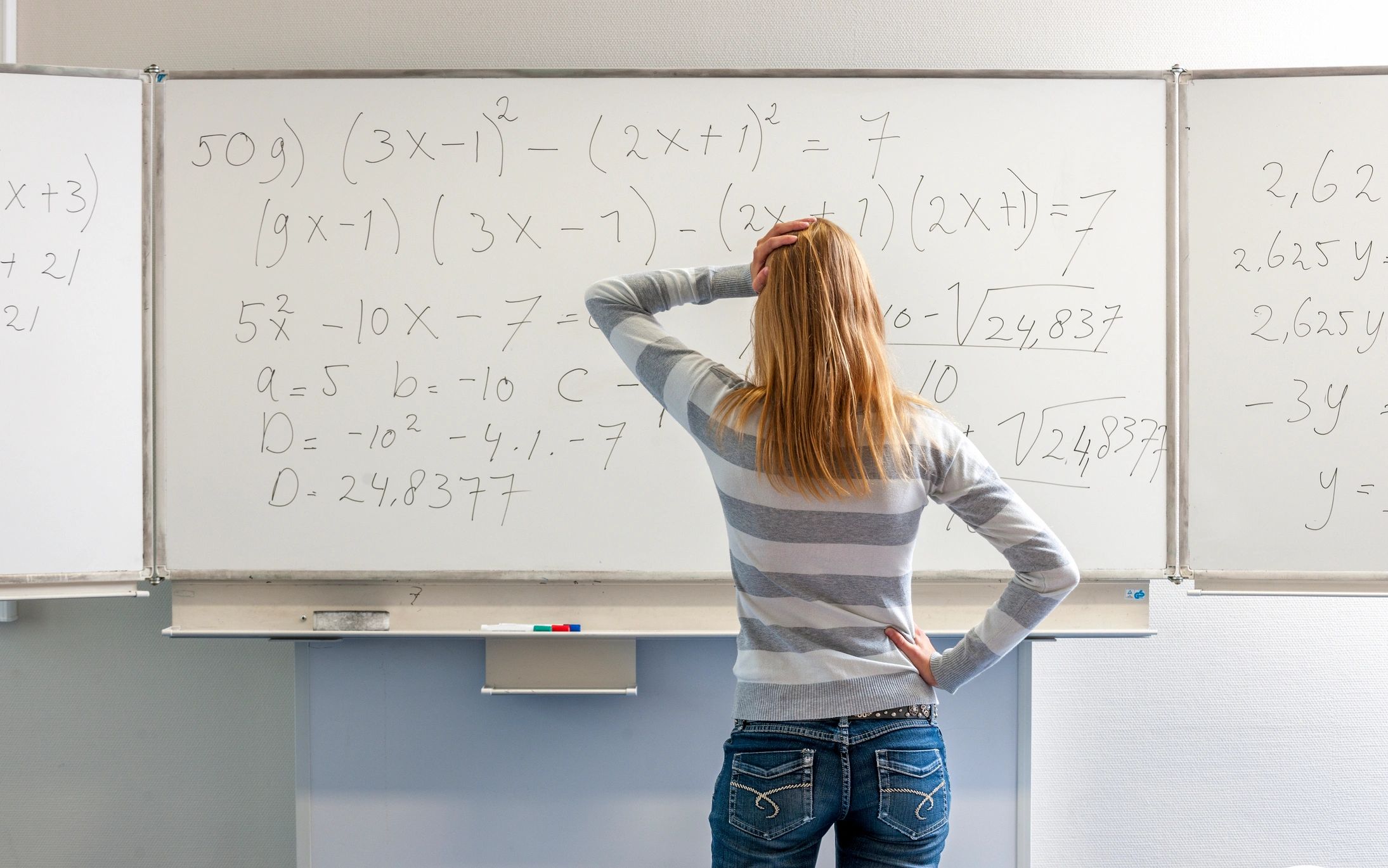 High school student studying mathematics in front of a whiteboard